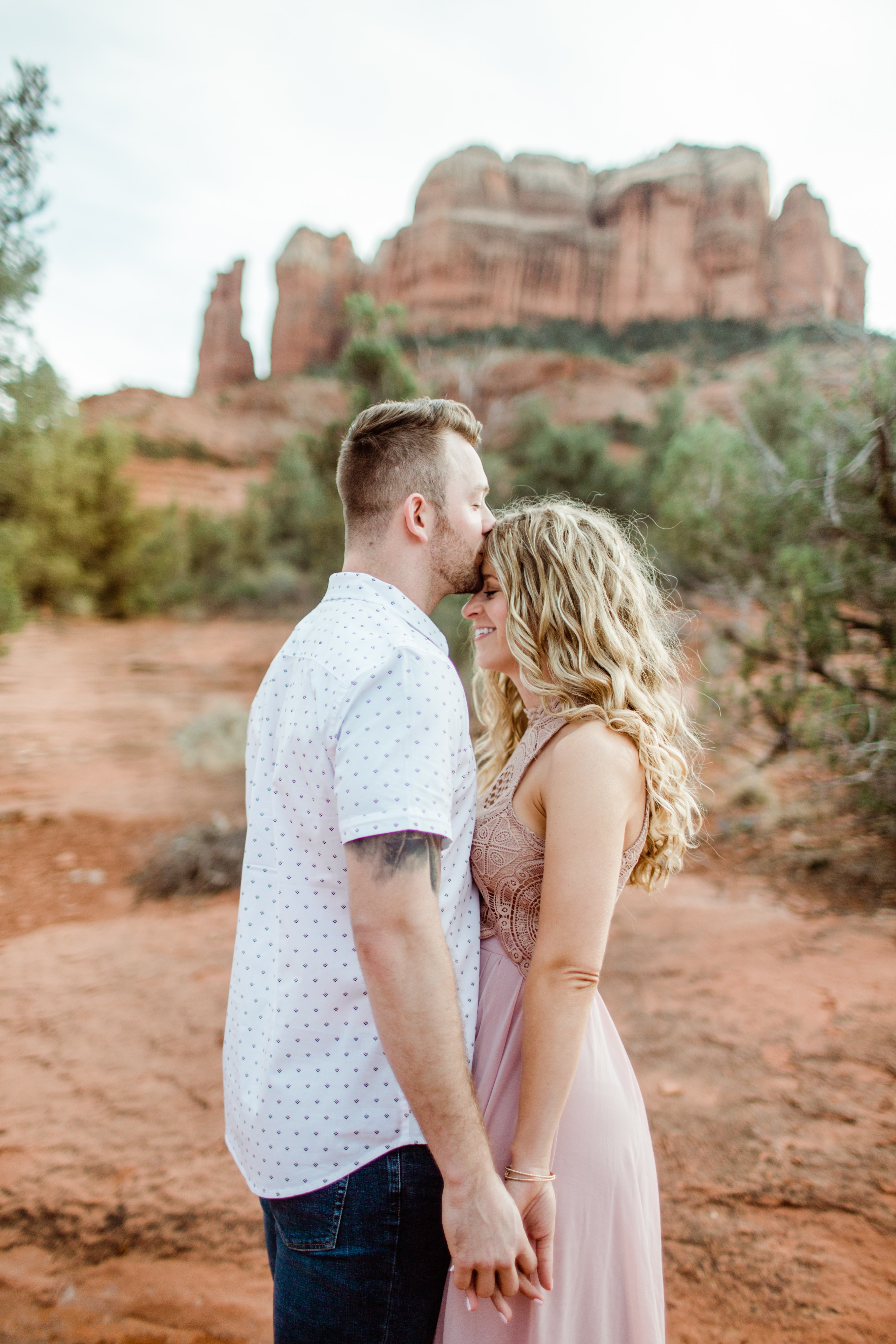 groom-kissing-bride-in-front-of-red-rocks