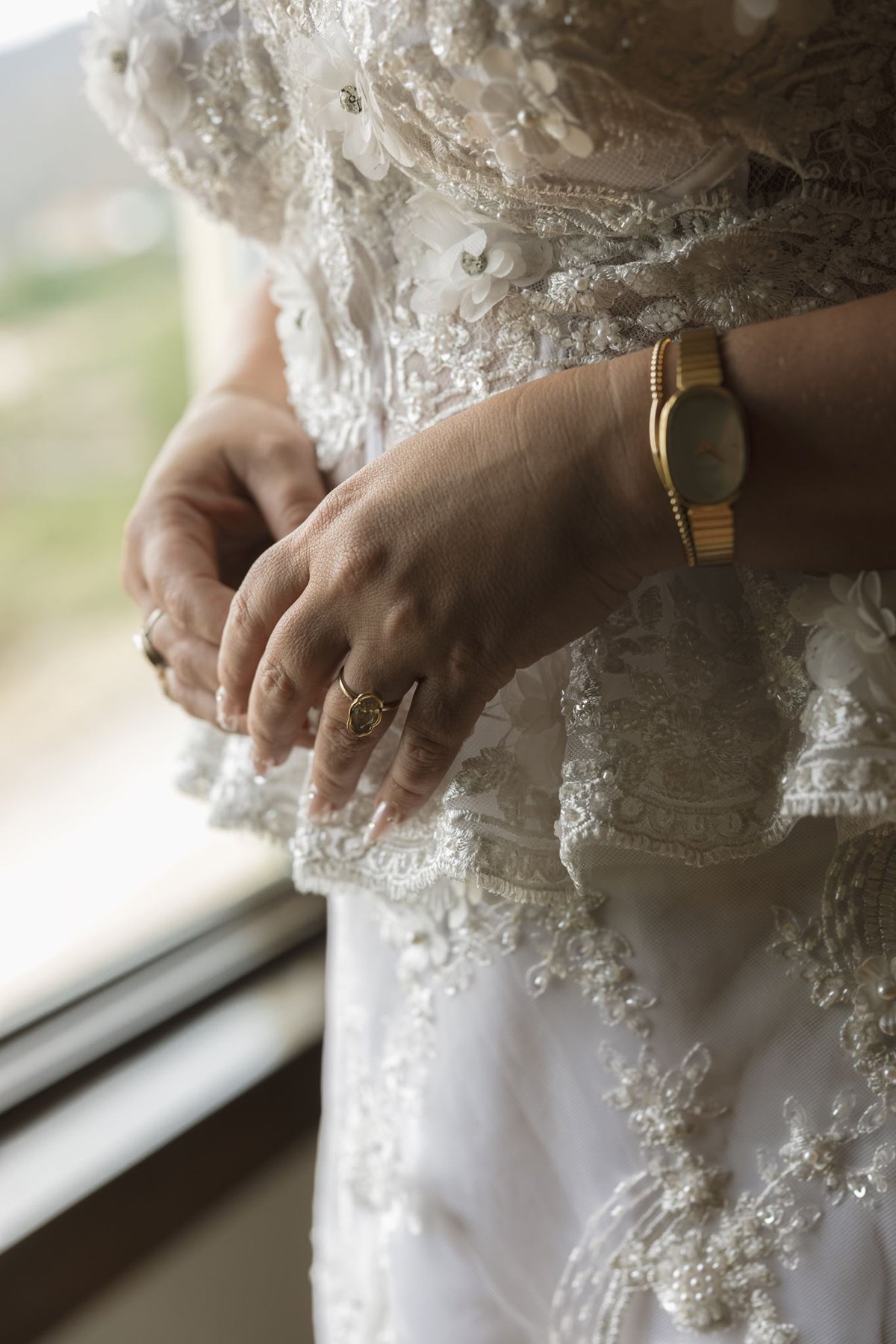 Close-up of Abigail’s rings and bracelet against her lace dress