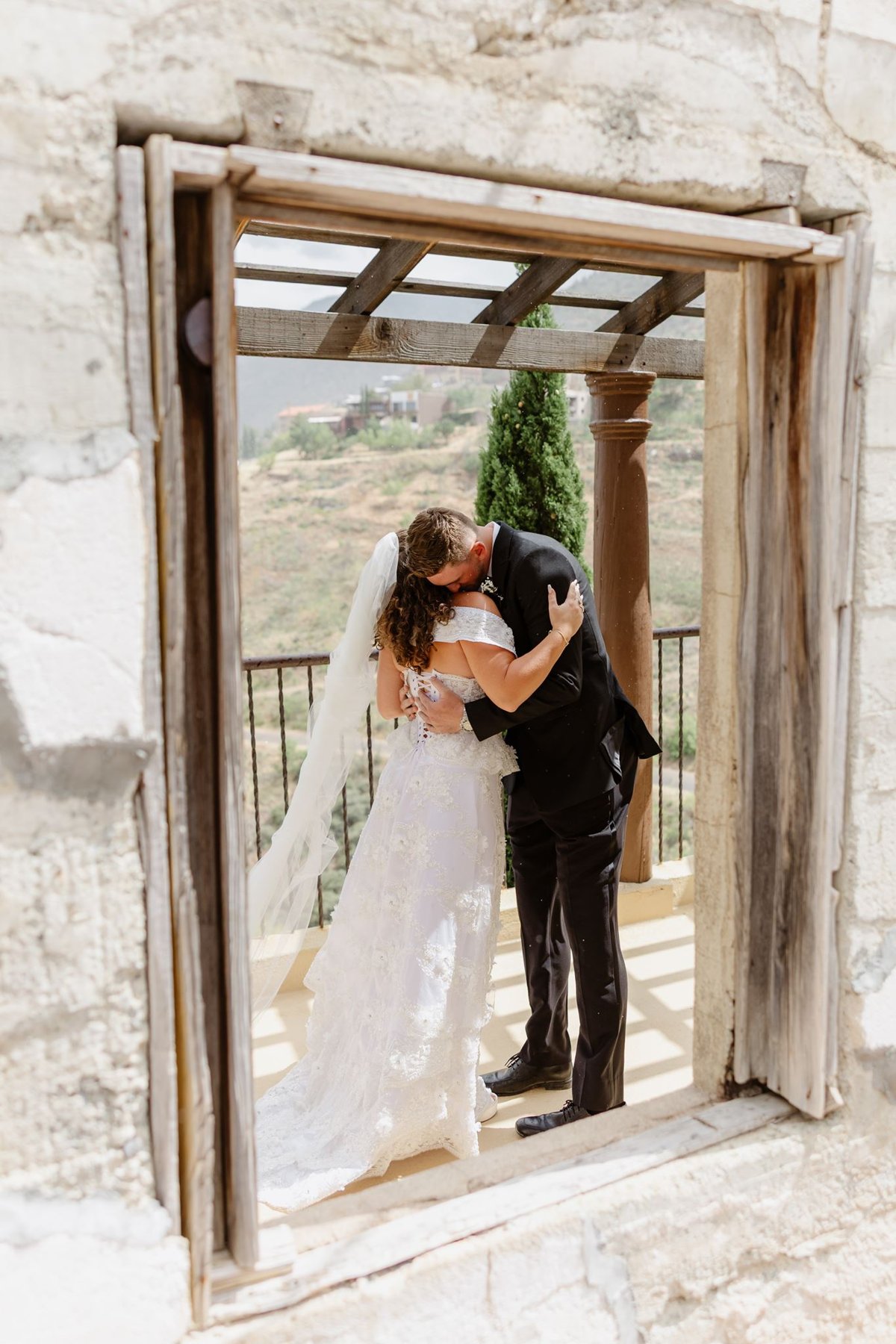 Abigail and Ethan kissing, framed through a window on the verandah