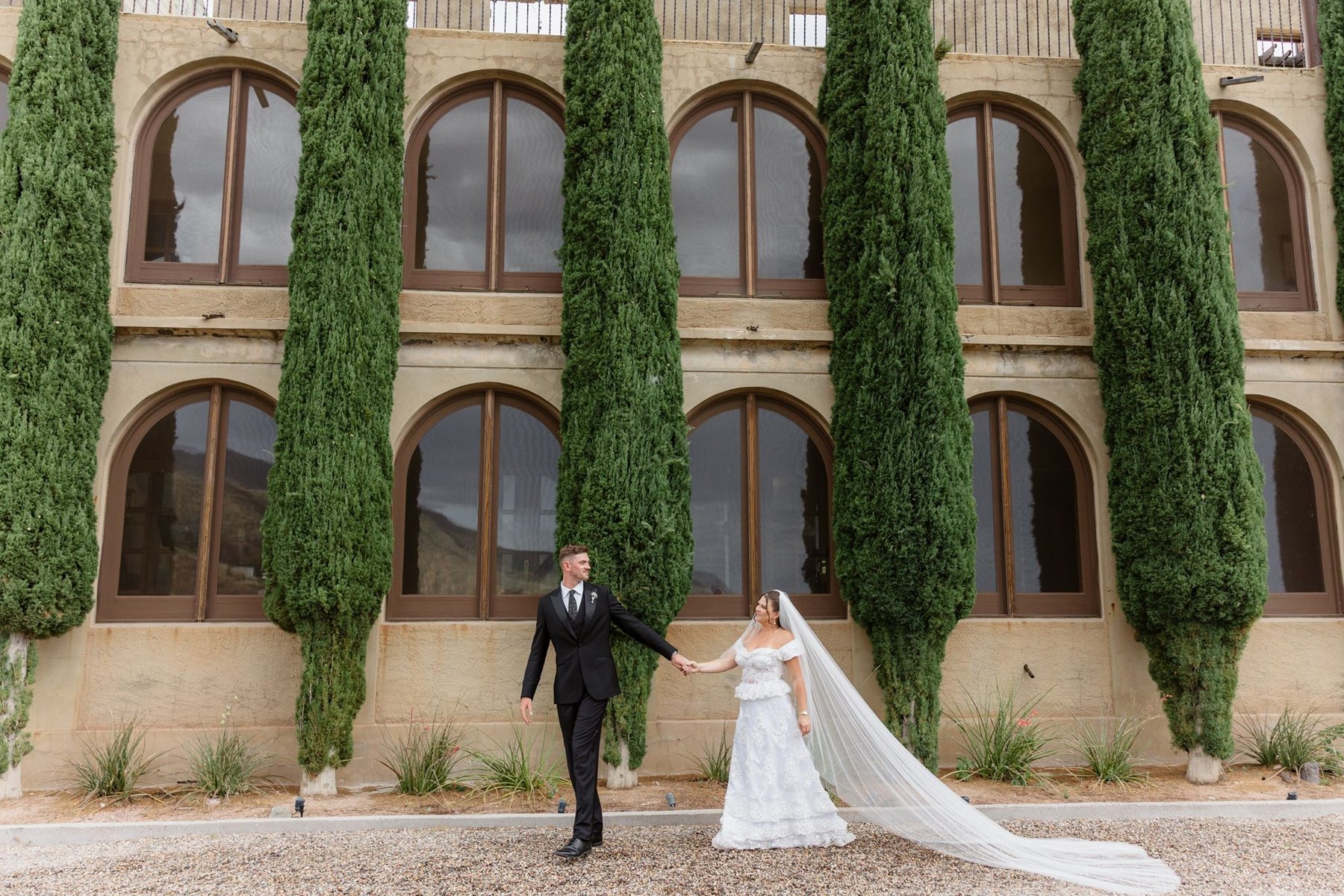 Abigail and Ethan beside tall cypress trees at The Little Daisy Jerome wedding venue
