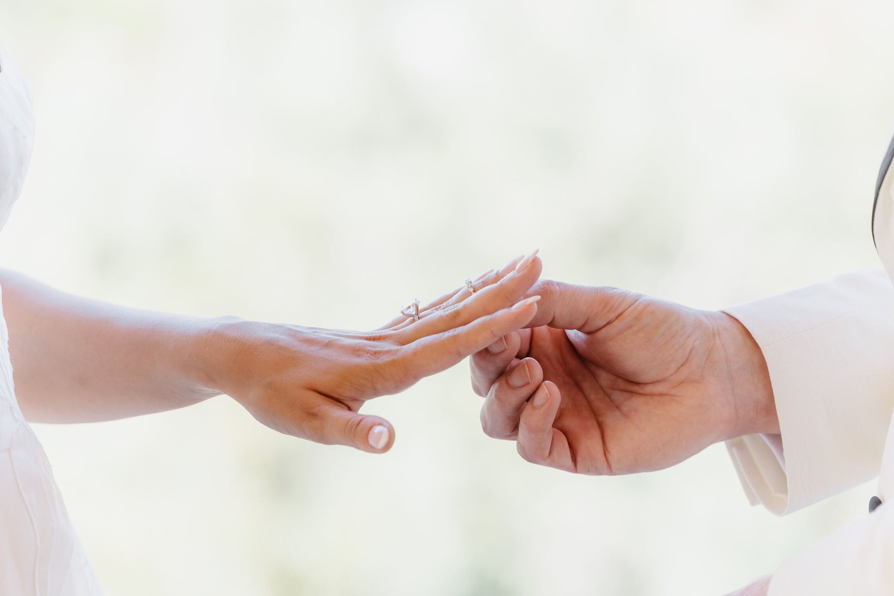 Close view of Brandon placing a wedding ring on Maggie’s hand