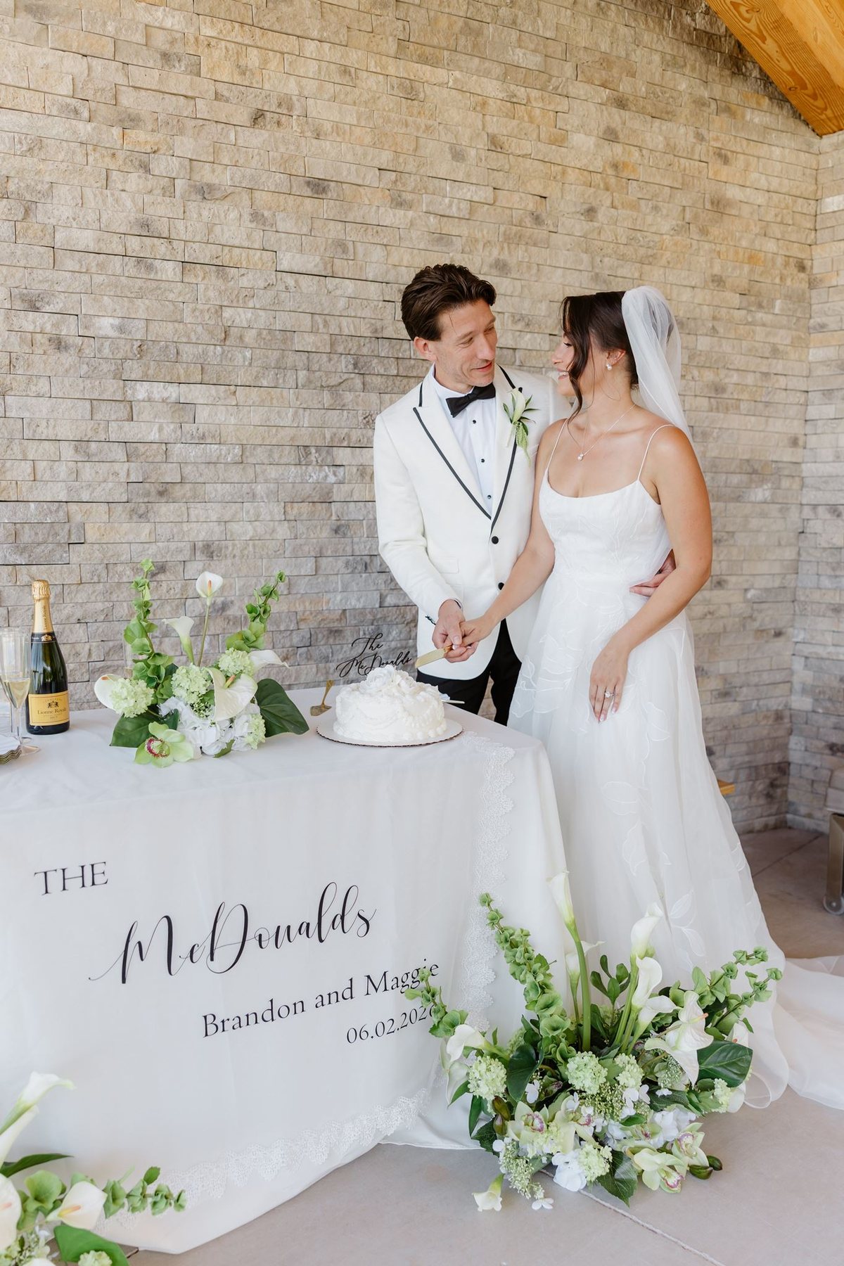 Maggie and Brandon cutting their white wedding cake at Eagle Dancer in Sedona