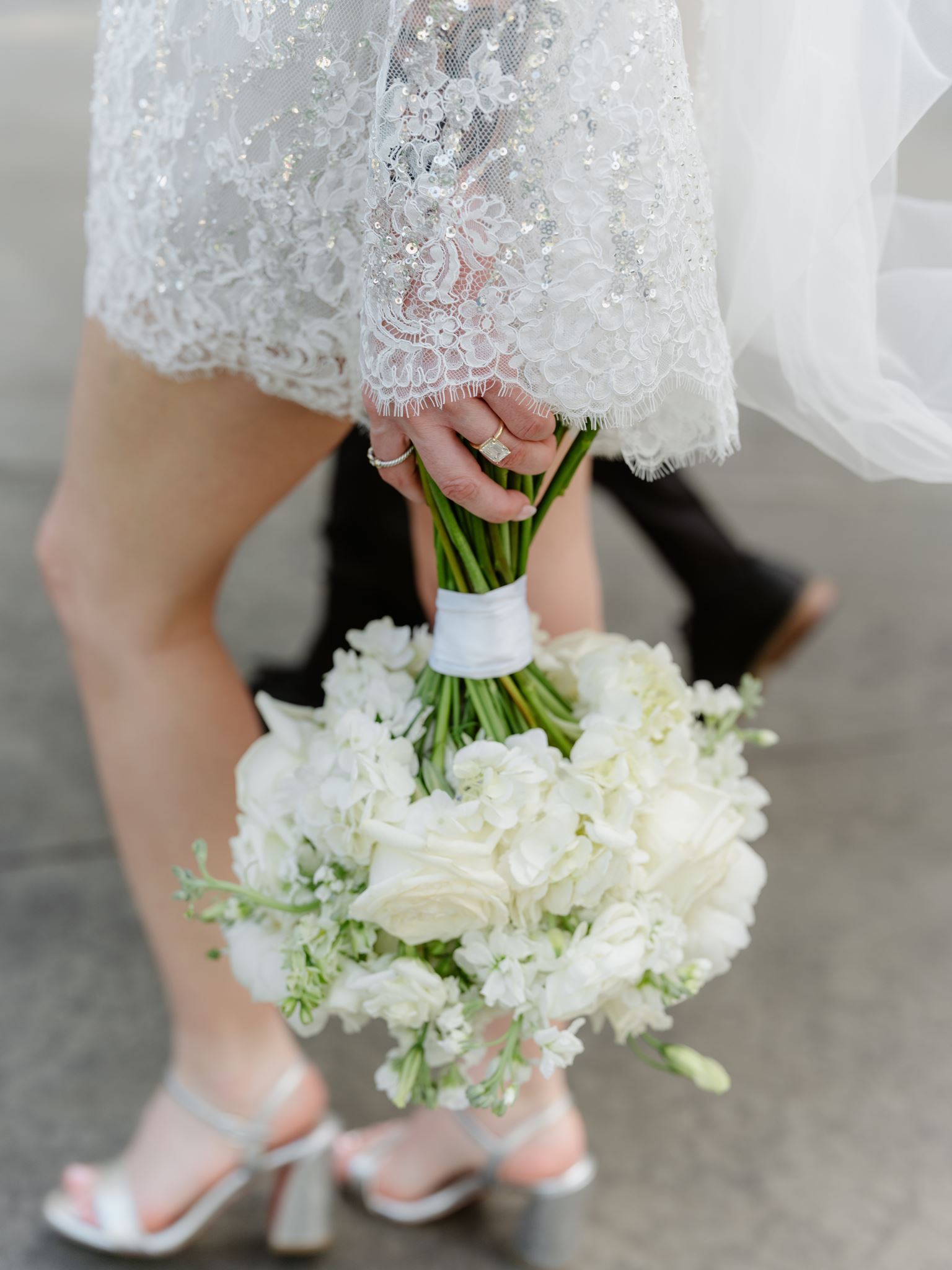 Close view of Erica’s bouquet, lace hem and silver bridal heels.