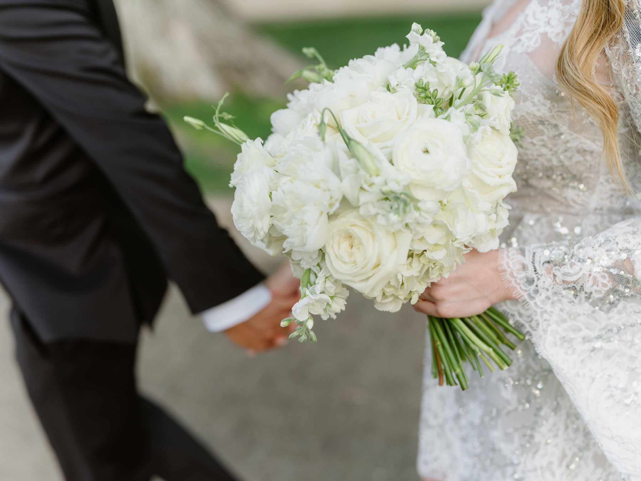 Close view of white roses and bridal flowers against Erica’s lace dress.