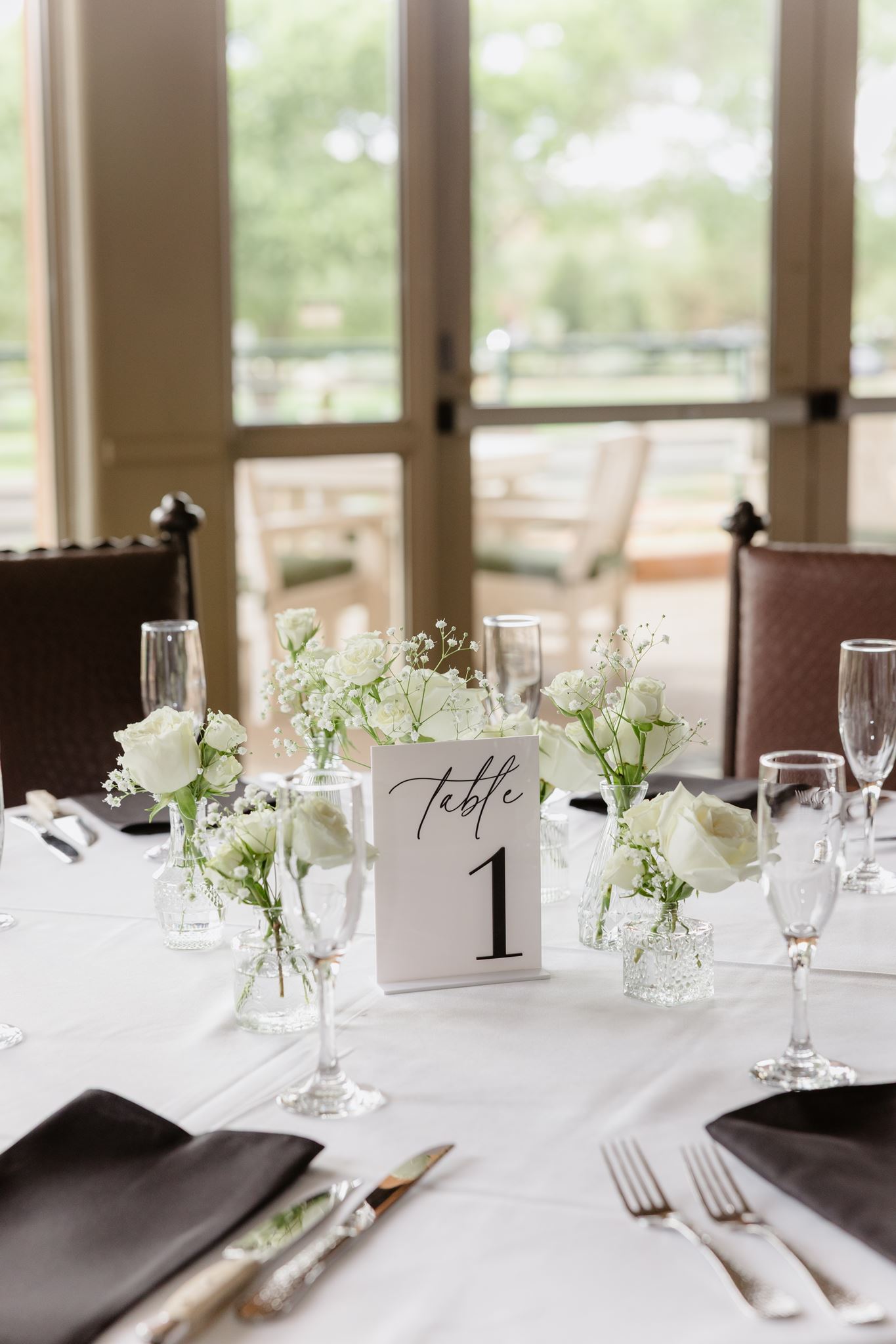 White floral centerpiece and black napkins on a wedding reception table at Sedona Golf Resort