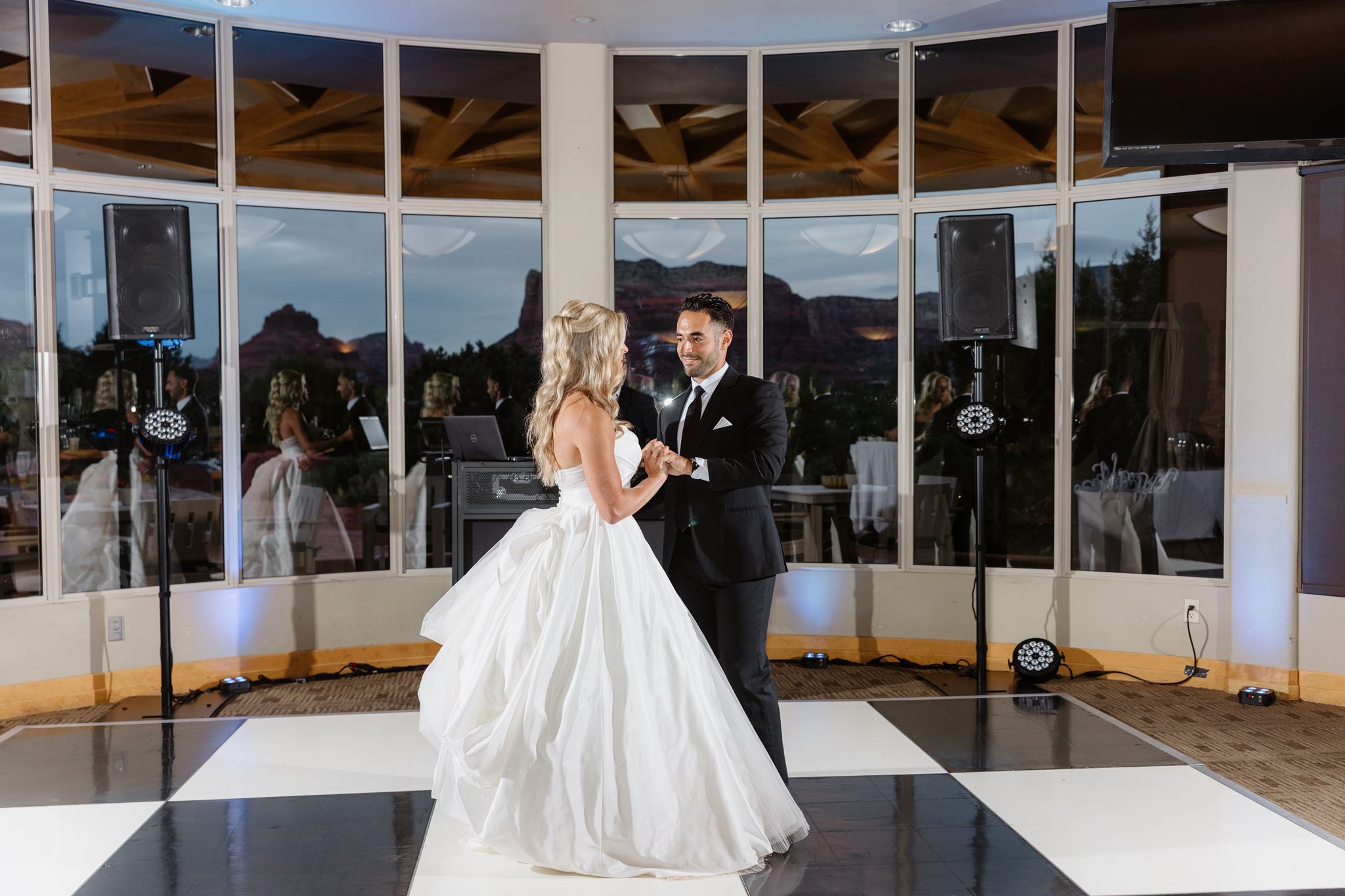 Mikalann and Alexander sharing their first dance on the black-and-white dance floor