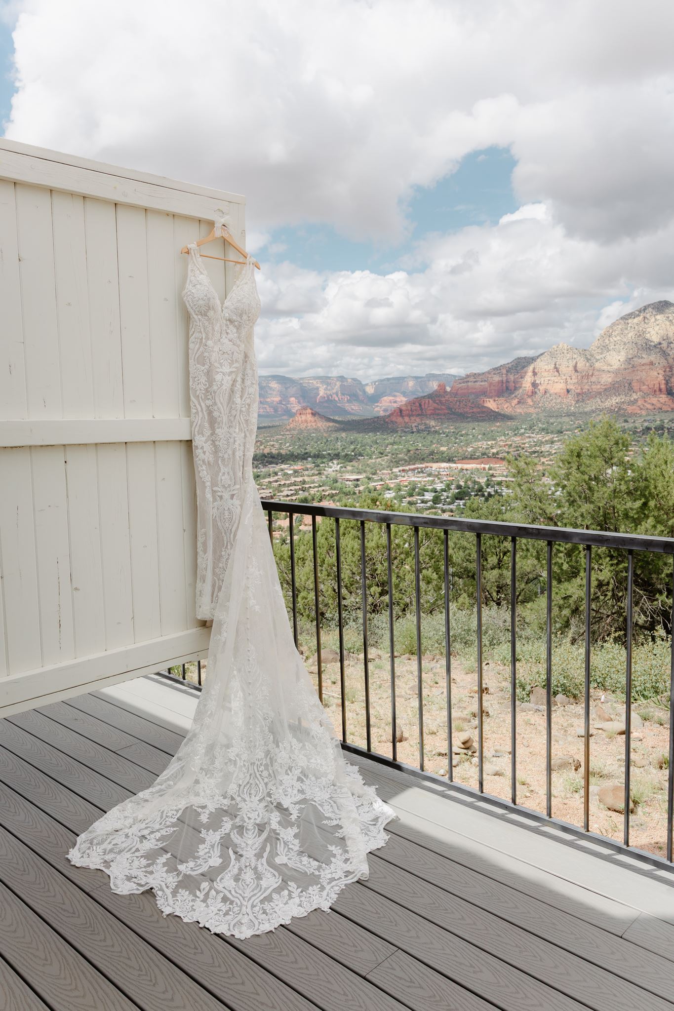 Lace wedding dress hanging on a balcony overlooking Sedona at Sky Ranch Lodge.